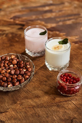 Yogurt with nuts on a wooden background. Side view. Summer food.