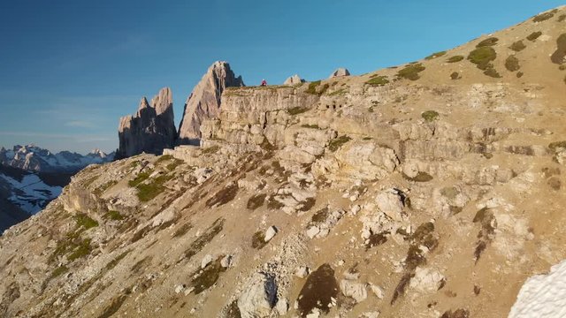 Drone aerial of hikers photographing Tre Cime di Lavaredo mountain in Sexten Dolomites Italy at sunrise. Hiking nature epic landscape in South Tirol. European Alps wanderlust.