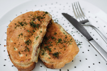 Birmingham eggs with bread on ceramic plate, fork and knife