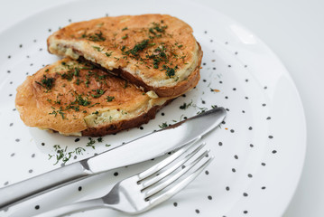 Birmingham eggs with bread on ceramic plate, fork and knife