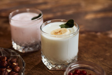 Yogurt with nuts on a wooden background. Side view. Summer food.