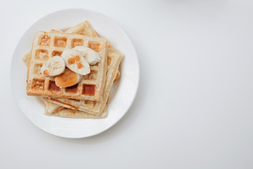 Fresh toasts with jam and bananas on white plate