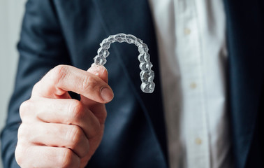 Professional showing dental clear aligners.