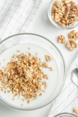 Porridge flakes in a bowl with milk. Granola for Breakfast with yogurt and walnuts.