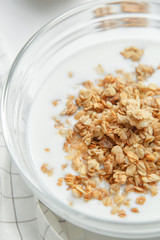 Porridge flakes in a bowl with milk. Granola for Breakfast with yogurt and walnuts.