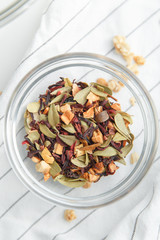 leafy natural green tea with fruit on a white background. Fruit tea leaves in a glass saucer.