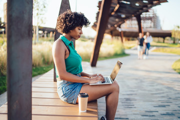 Serious female browsing laptop in street