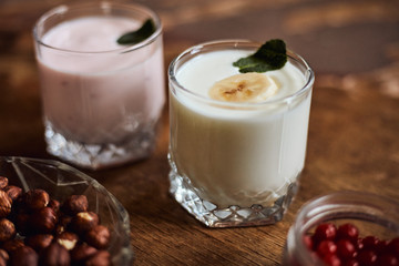 Yogurt with nuts on a wooden background. Side view. Summer food.