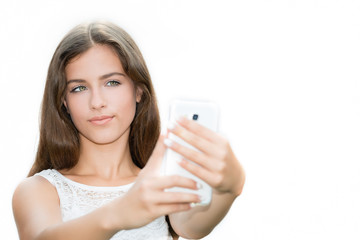 Teenage girl taking a self portrait photo, selfie on the white background.Copy space