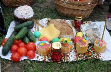 Easter cakes and fresh vegetables with colored eggs of different colors on a Ukrainian towel in Kiev, April 28, 2019.