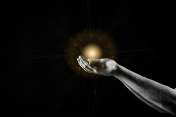 Man's hands palms up, giving care and support, praying. with majestic lights and flare.