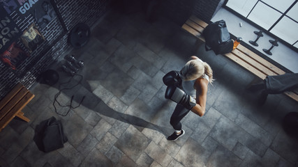 Professional Female Boxer Exercises Air Punches while Wearing Sportswear and Fighting Gloves in the Hardcore Gym. Strong Beautiful Girl Kickboxing and Self Defense Workout. Top Dramatic View