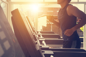 Young man in sportswear running on treadmill at gym healthy lifestyle