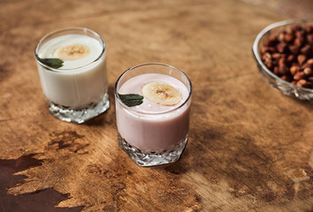 Yogurt with nuts on a wooden background. Side view. Summer food.