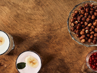 Yogurt with nuts on a wooden background. View from above. Summer food.