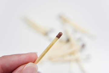 wooden match in the hand with matches on the white backgtound