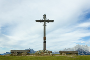 Fototapeta na wymiar Large crucifix on mountain summit in the Austrian Alps during summer