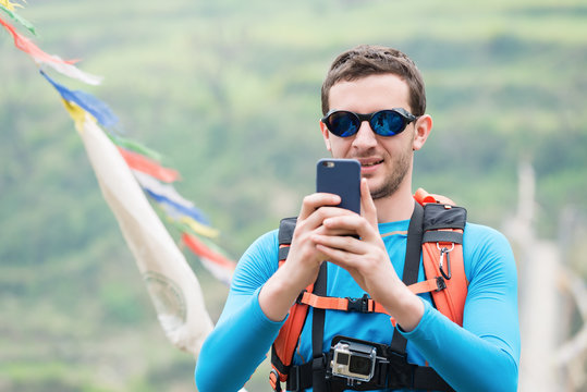 Portrait of young mountaineer taking photo in Himalayas mountains.Copy space
