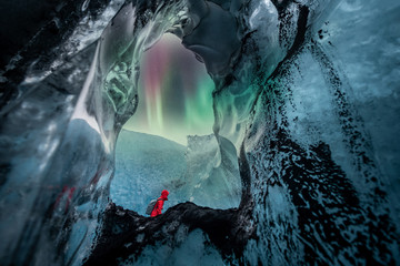 Northern lights aurora borealis over glacier ice cave.