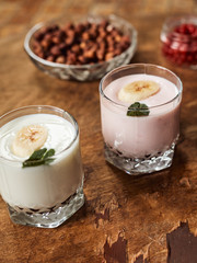 Yogurt with nuts on a wooden background. Side view. Summer food.