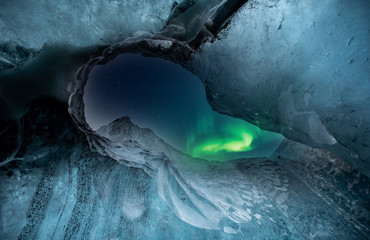 Northern lights aurora borealis over glacier ice cave.