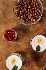 Yogurt with nuts on a wooden background. View from above. Summer food.