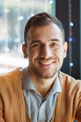 Fototapeta premium Portrait of a successful man who is in a cafe. The man smiles. Portrait close-up.