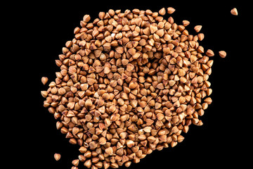 buckwheat brown seeds on a black background top view