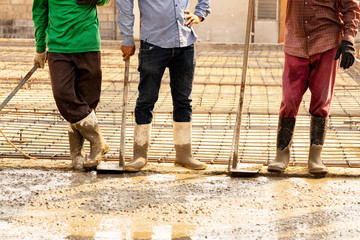 Three workers  extended their  breaks beside wet  concrete.