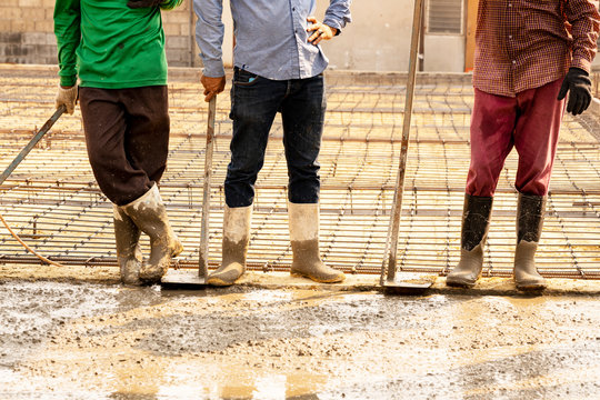 Three workers  extended their  breaks beside wet  concrete.