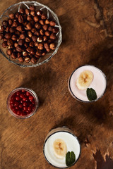 Yogurt with nuts on a wooden background. View from above. Summer food.