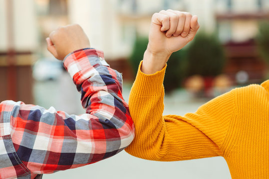 Friends bump elbows outdoors. Coronavirus epidemic. Social distancing. Fight coronavirus.