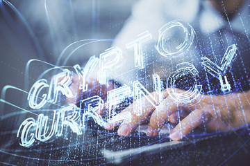 Crypto currency theme hologram with businessman working on computer on background. Concept of blockchain. Double exposure.