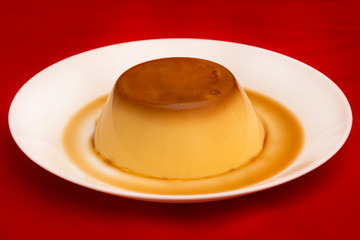 cream caramel dessert in white dish on black background