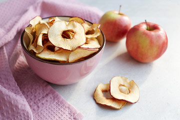 Homemade chips from dried apples in a bowl on a light background