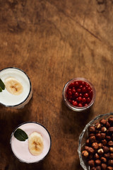 Yogurt with nuts on a wooden background. View from above. Summer food.