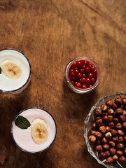 Yogurt with nuts on a wooden background. View from above. Summer food.
