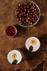 Yogurt with nuts on a wooden background. View from above. Summer food.