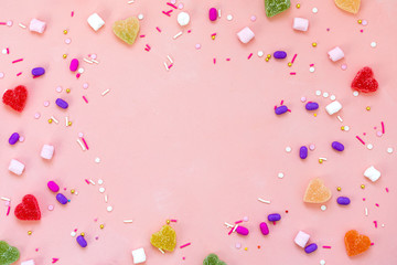Top view decoration assorted gummy candies and jelly sweets happy holiday background concept. Flat lay colorful candy on beautiful pink desk. Copy space.