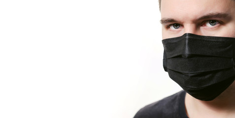 Closeup frowning man in disposable medical mask isolated on a white background. Covid-19 coronavirus epidemic. Quarantine and self-isolation mode to save the population.