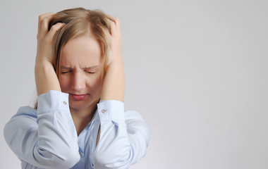 young blonde girl holds her head. Woman with headache concept