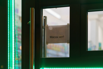 Entrance to the pharmacy. The inscription in Russian, translation - MEDICAL MASKS NOT AVAILABLE....