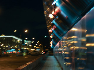 Defocused photography of Moscow cityscape in night time. Blurred motion of cars at motorway. Illuminated buildings. Blue, red, white and gold colors. Coronavirus pandemic time in city. © Yury and Tanya