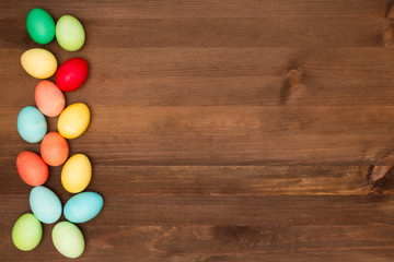 easter eggs collection as a background. Multi-colored eggs in a row.
Easter eggs on a brown wooden table.