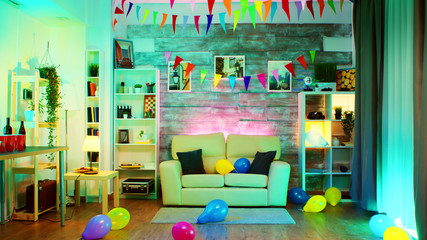 Party decorated room with neon lights on the wall and a disco ball