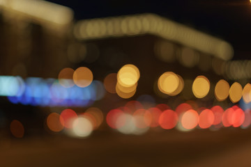 Defocused photography of Moscow cityscape in night time. Blurred motion of cars at motorway. Illuminated buildings. Blue, red, white and gold colors. Coronavirus pandemic time in city.
