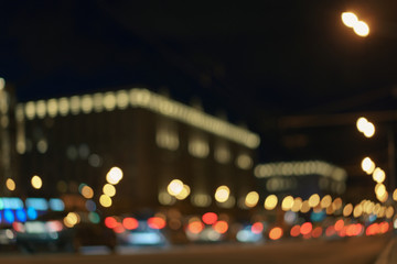 Defocused photography of Moscow cityscape in night time. Blurred motion of cars at motorway. Illuminated buildings. Blue, red, white and gold colors. Coronavirus pandemic time in city.