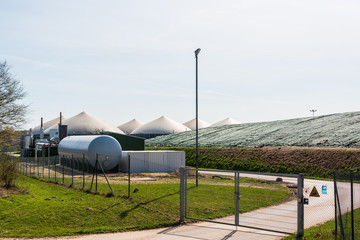 Windkrafträder und Biogasanlage auf einem Feld bei Oldesloe im Frühjahr