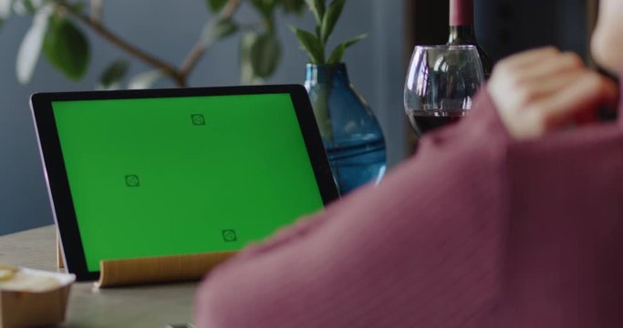 GREEN SCREEN CHROMA KEY Caucasian female having a glass of wine while using her tablet