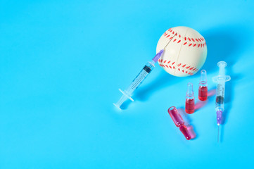 Baseball ball near syringe and ampoule on blue background. Concept of doping in professional sport....